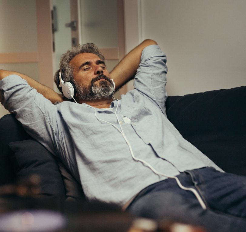 Man relaxing with eyes closed while wearing headphones