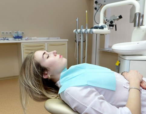 Woman relaxing in dental chair with sedation dentistry in Edison, NJ