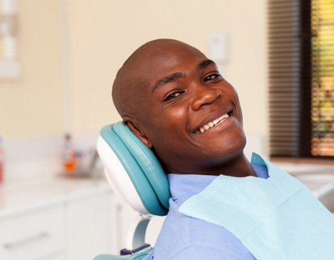 Man sitting in a dental chair and smiling