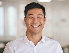 Man in white button-up shirt smiling