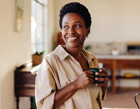 Smiling woman enjoying coffee at home