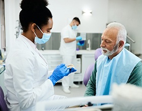 A dentist explaining how dentures work to a patient