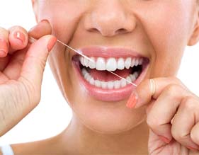 person smiling while flossing their teeth