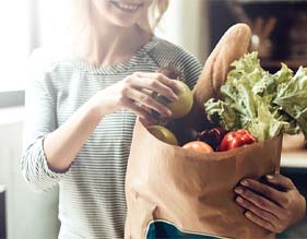 close up of woman unbagging healthy food
