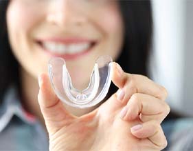 woman holding up mouthguard