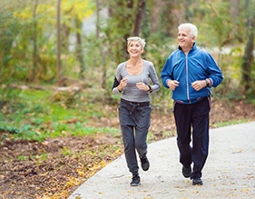 Older couple with dental implants in Edison jogging outside