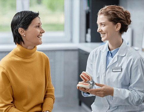 a patient speaking with her dentist about implant dentures