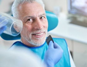 Older patient with dental implants in Edison smiling at dentist