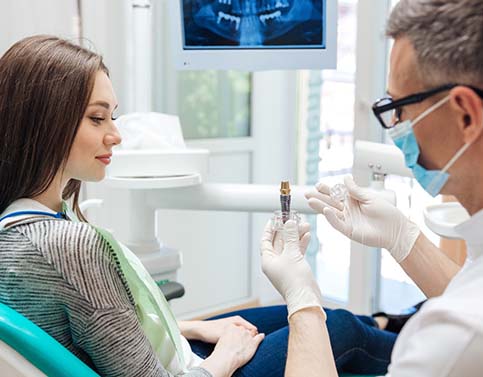 dentist showing a dental implant to a patient