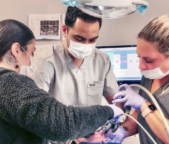 Dentist and team members treating dental patient