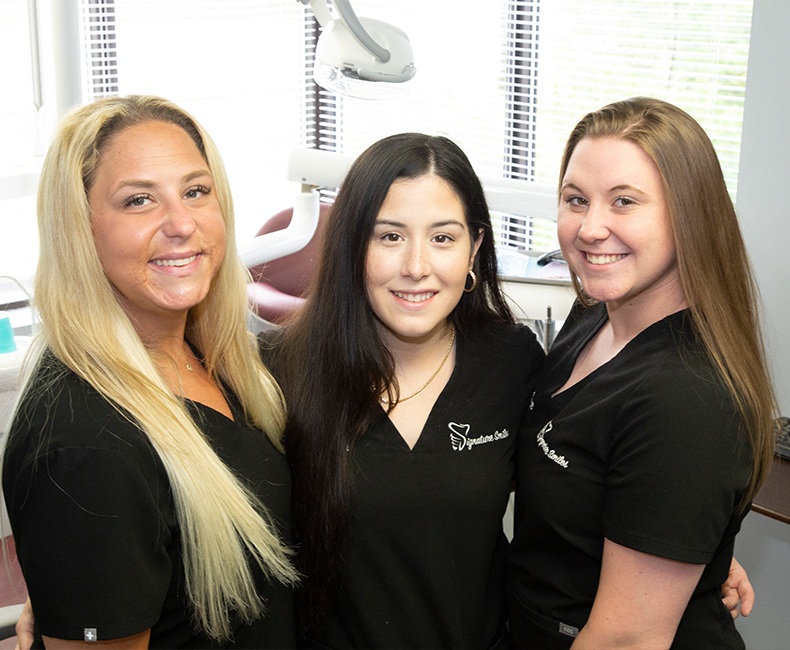 Three smiling Edison dental team members