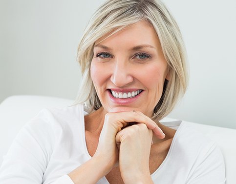 Woman smiling after dental bridge tooth replacement