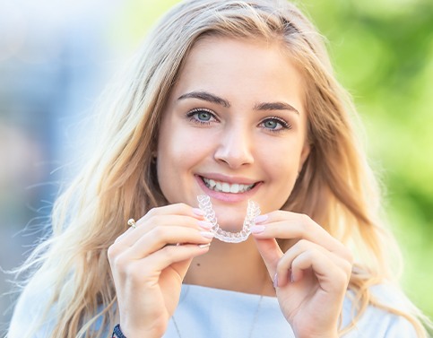 Woman placing an Invisalign clear alignment tray