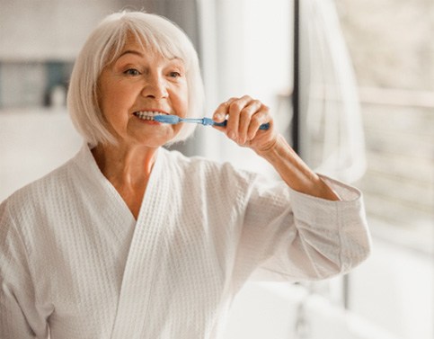 a patient brushing their dental implants