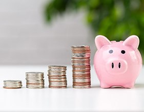 pile of coins next to a piggy bank