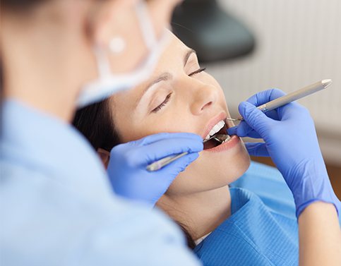 Patient under general anesthesia receiving dental exam