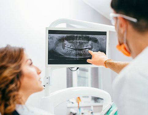 Dentist and patient looking at dental x-rays
