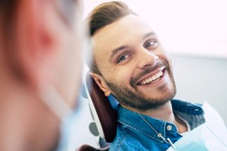 Man with white teeth smiling at dentist during appointment