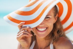 Woman in sunhat smiles after visiting her Edison dentist