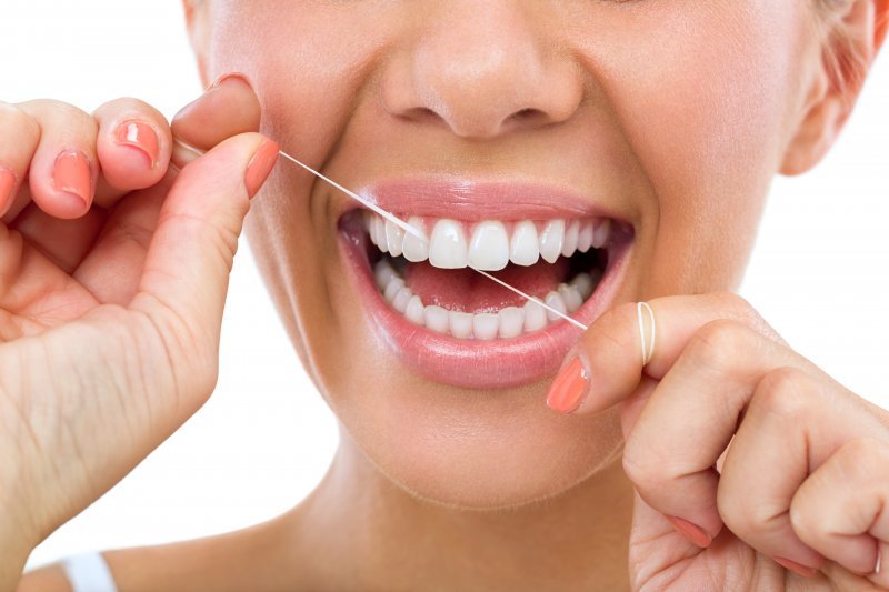 Closeup of woman smiling while brushing her teeth