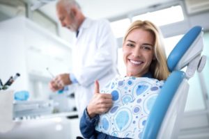 woman giving a thumbs-up while visiting her emergency dentist in Edison 
