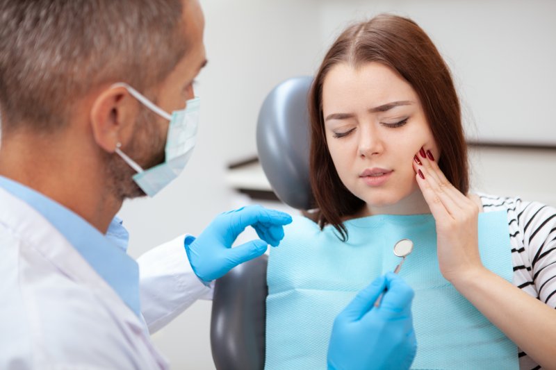 young woman with dental emergency 