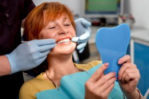 a woman smiling happily with her dental implants