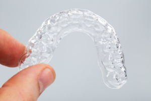 Close up of someone holding an Invisalign tray
